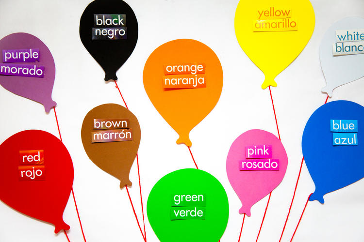 Colored balloons labeled with spanish and english words